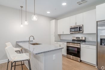 A kitchen with white cabinets and a granite countertop.